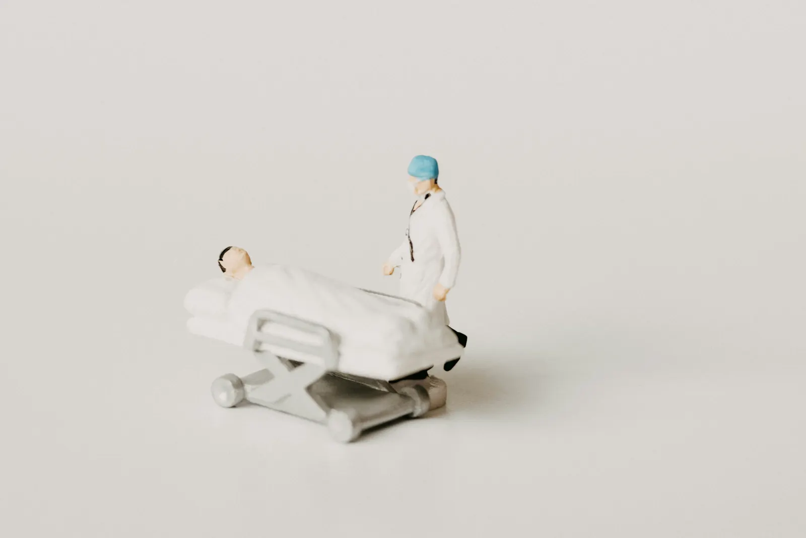 Figurine de médecin auprès d'un patient sur un brancard